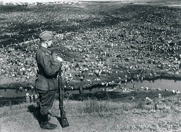 German soldier is guarding captured Soviet soldiers after the Battle of Uman 1941.jpg