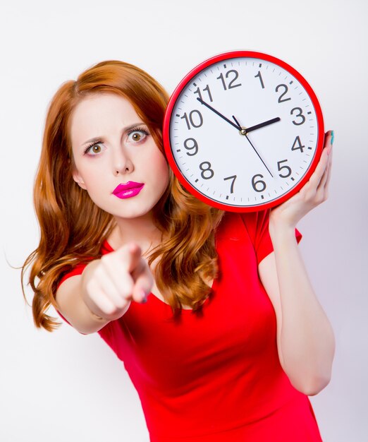 surprised-redhead-girl-in-red-dress-with-big-clock-on-white_87910-8084.jpg