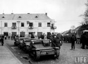 Hungarian soldiers standing in front of home damaged during fighting..jpeg