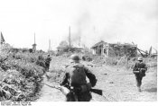 Bundesarchiv_Bild_146-1974-099-45,_Russland,_Gatnoje,6.08.41_Soldaten_bei_Besetzung_einer_Ortsch.jpg