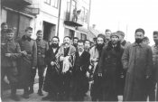 Smiling German soldiers surround a group of religious Jewish men on the street in Minsk.jpg