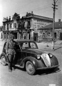 26993_Soldato presso un'automobile in una via di un paese dell'Ucraina nell'agosto 1941.jpg