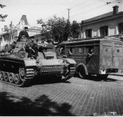 Autocolonna militare in marcia verso le prime linee attraversa un paese dell'Ucraina.jpg