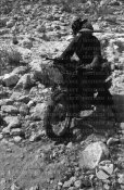 3_Un bersagliere in motocicletta scende lungo un sentiero pietroso.jpg