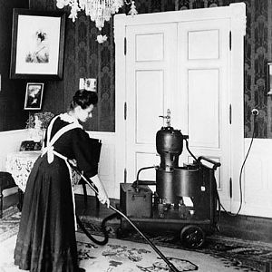 Домохозяйка за работой с одним из первых пылесосов от компании Сименс, 1906 год.