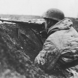 Немецкий десантник, вооруженный пистолетом-пулеметом MP-40 в окопе.jpg