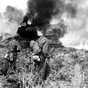 Солдаты войск СС идут мимо подбитого под Варшавой советского танка Т-34..jpg